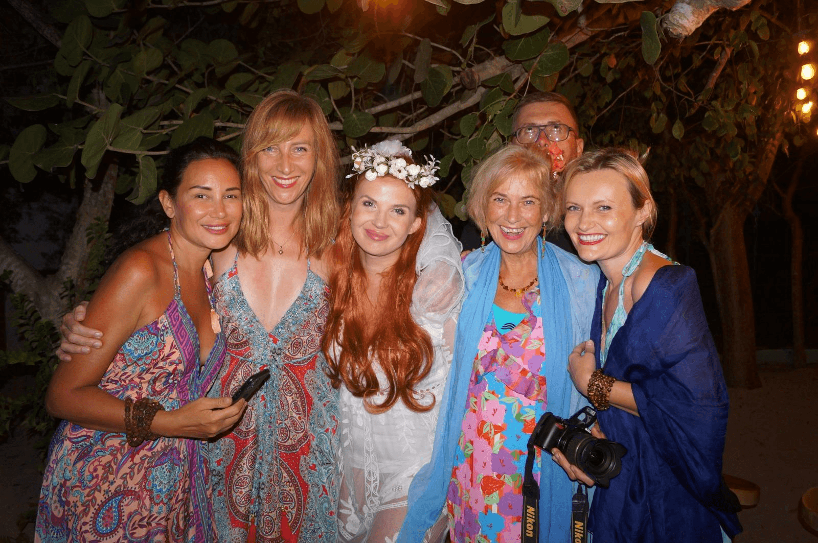 Guests together under the trees at night at the close of a retreat